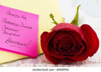 Red rose on map with note about wedding and honeymoon plans