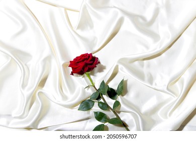 A Red Rose On A White Bed