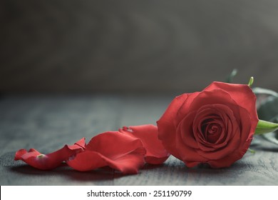 Red Rose With Petals On Wood Table