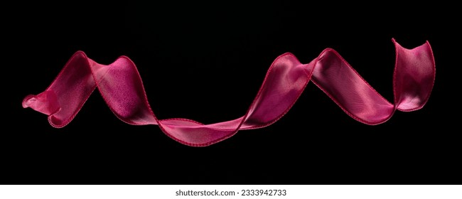 Red rose ribbon long straight fly in air with curve roll shiny. Red yellow ribbon for present gift birthday party to wrap around decorate, curl curve long straight. Black background isolated