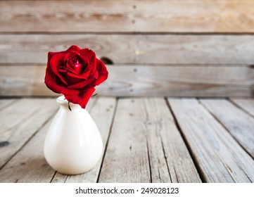 Red Rose In Vase On Wooden Table