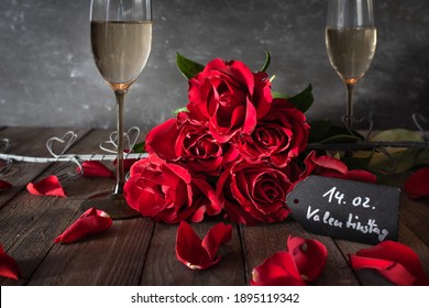 Red roses with champagne dekorated on rustic wooden boards. Romantic still life for valentine's day.