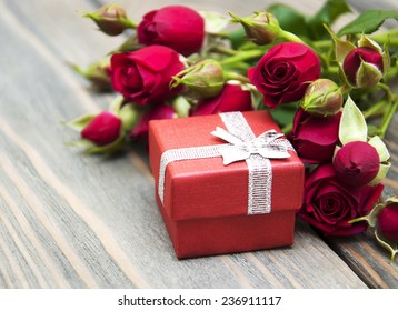 Red roses  and gift box on a wooden background - Powered by Shutterstock