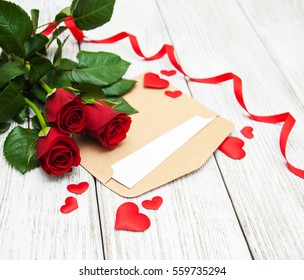 Red roses and greeting card on a wooden table - Powered by Shutterstock