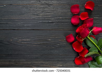 Red roses on a black wooden background. With copy space