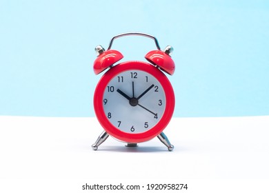 red round analog alarm clock isolated on blue background. time 10:10.