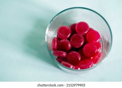 Red Round Pills For Throat Treatment In A Pill Box Shifted To The Right On A Bluish Background