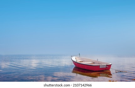 Red rowing boat in calm waters