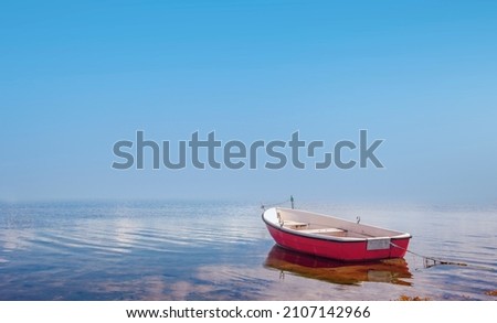 Red rowing boat in calm waters
