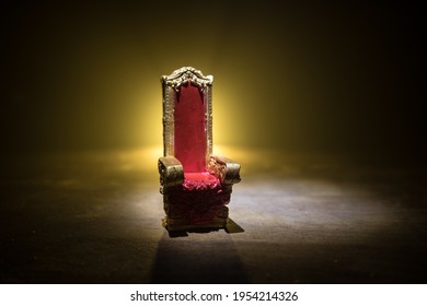 Red royal chair miniature on wooden table. Place for the king. Medieval Throne. Selective focus