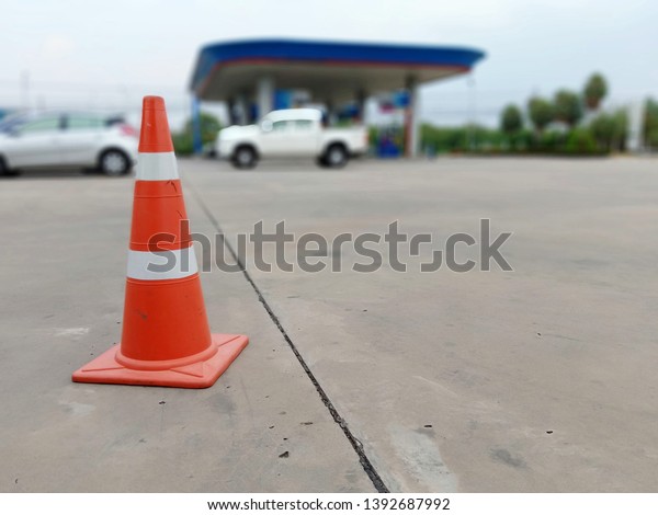 Red rubber cone on concrete floor in gas station,\
blurred background image