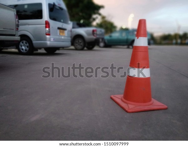 Red rubber cone on concrete floor in gas station,
blurred background image