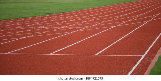 Red Running Track And Green Field