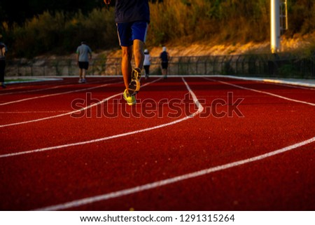 Red running track with runner's feet. Sport stadium for run. 