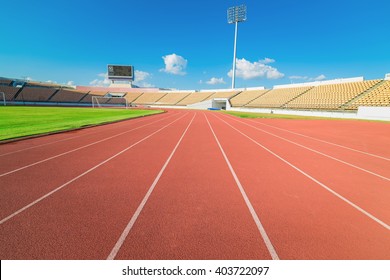 Red Running Track In Stadium On Blue Sky.