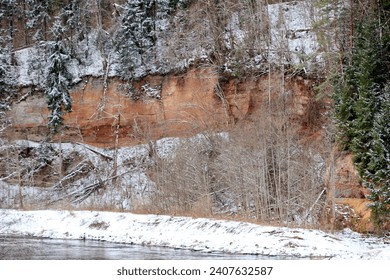 red sandstone cliffs on the river bank in winter