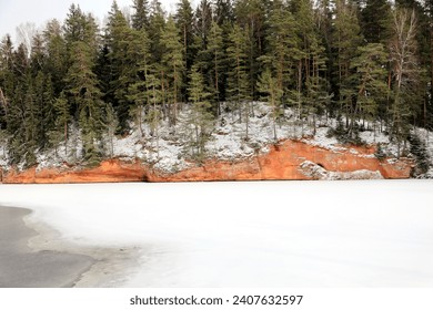 red sandstone cliffs on the river bank in winter