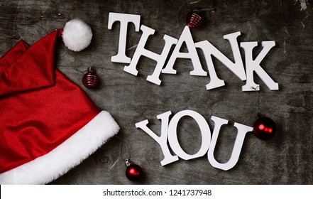 Red Santa Hat And Letters Thank You On A Grey Textured Wooden Background