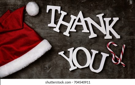 Red Santa Hat And Letters Thank You On A Grey Textured Wooden Background