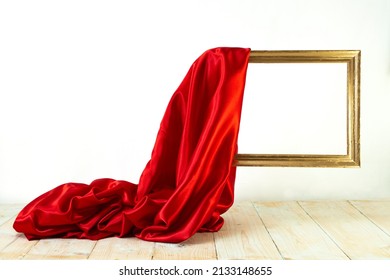 Red Satin Cloth Unveiling A Golden Frame. Levitating Frame, Mockup For Presentation.