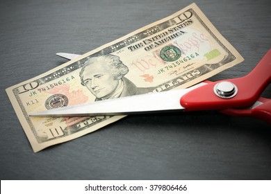 Red Scissors Cut Money On Black Background. Financial Concept