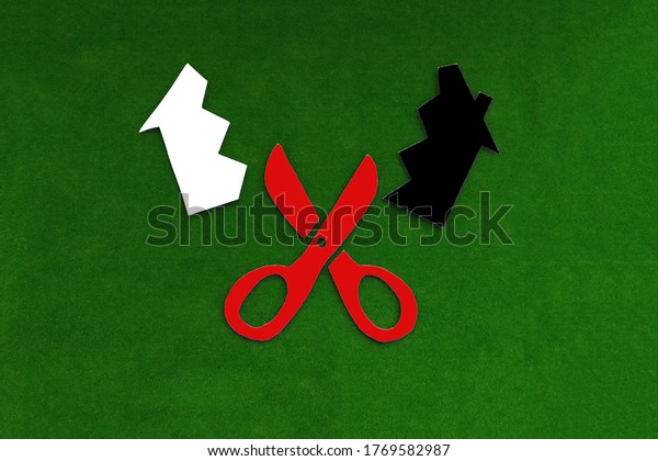 Red scissors that cut the house into two\
halves white and black on a green background. Real estate section.\
share ownership.