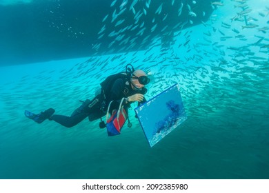 Red Sea Egypt - December 26, 2008: Andre Laban with a picture painted under water. Andre Laban is an associate of Jacques-Yves Cousteau and a member of the crew of the legendary ship Calypso.