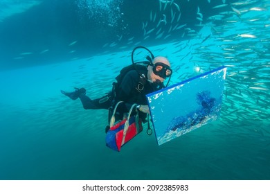 Red Sea Egypt - December 26, 2008: Andre Laban with a picture painted under water. Andre Laban is an associate of Jacques-Yves Cousteau and a member of the crew of the legendary ship Calypso.