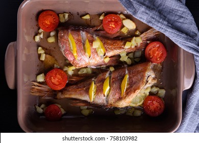 Red Sea Perch Or Red Grouper With Tomatoes And Lemon Baked And Cooked On Dark. Top View