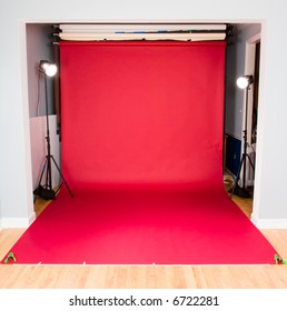 Red seamless paper backdrop setup in a studio with hair light strobes firing. Good for additional design elements such as a message or adding a model or object to the scene.