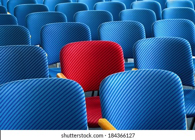 Red Seat As An Eyecatcher In The Middle Of Rows Of Empty Blue Seats, Conceptual Image