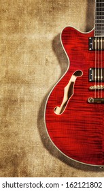 red semi-hollow electric guitar on brown canvas background