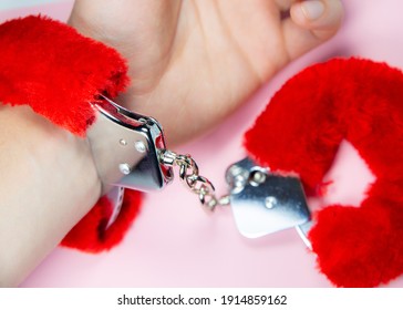 Red Sexy Fluffy Handcuffs On Man's Hand.