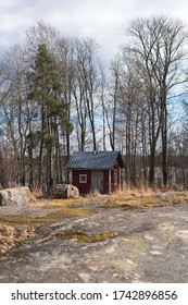 A red shack with bare trees in the background