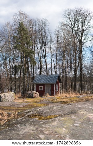 A red shack with bare trees in the background
