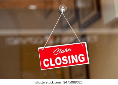 Red sign hanging at the glass door of a shop saying in English: "Store closing". - Powered by Shutterstock