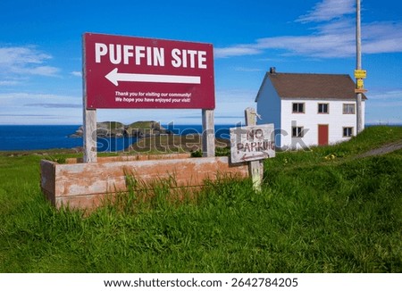 A red sign points puffin enthusiasts to a puffin viewing site in Elliston, Newfoundland
