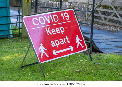 A Red Sign Warning About The Coronavirus Pandemic And Social Distancing At An Outdoor Event As Lockdown Eases In England