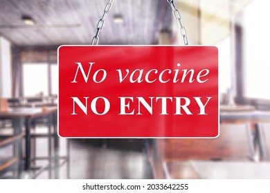 A Red Sign In The Window Of A Shop Displaying The Message Text No Vaccine, No Entry.