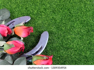 Red silk roses, a horseshoe and artificial green grass for the running of the thoroughbred race called the Kentucky Derby. Copy space