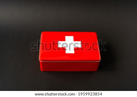 Red simplistic first aid box, black background