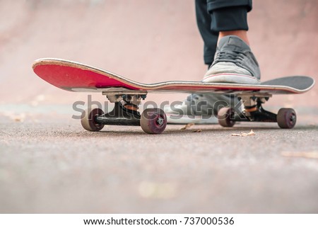 Red skate Legs in sneakers. Sports, teenager, riding area. Active sports. Street physical activity. Skate ride