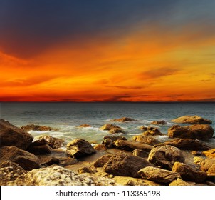 Red sky over a rocky seashore. Sunset landscape. - Powered by Shutterstock