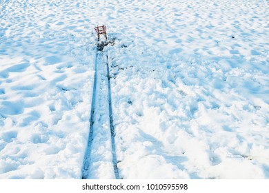 Red Sled At The End Of Track In Snow.