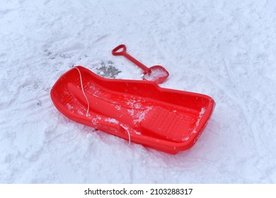 Red Sled And Shovel In The Snow