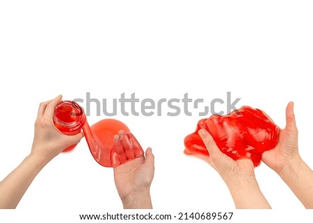 Red slime toy in woman hand isolated on white. Top view. 