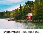 Red Small Finnish Wooden Sauna Log Cabin On Island In Autumn Season.