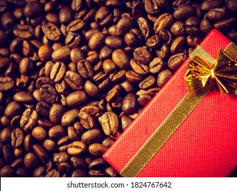 Red small gift box with bow on roasted brown coffee beans background. - Powered by Shutterstock