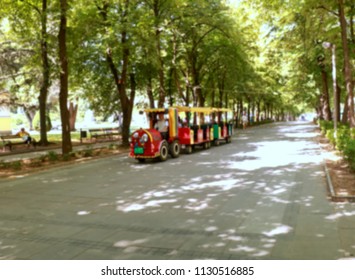 Red small train going down the street,blur