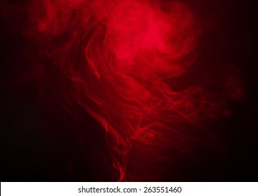 Red smoke over black studio background